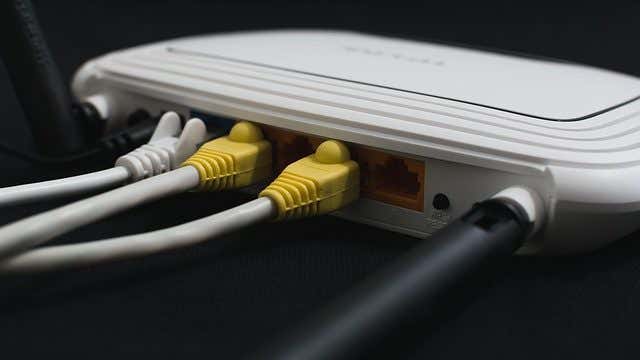 A router with yellow Ethernet cables connected at the back, showcasing image.