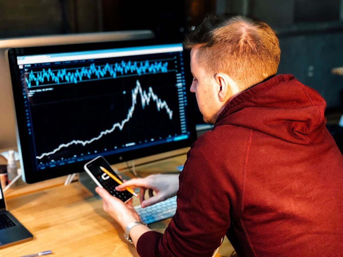 A person analyzing stock market data on a computer screen, highlighting image.