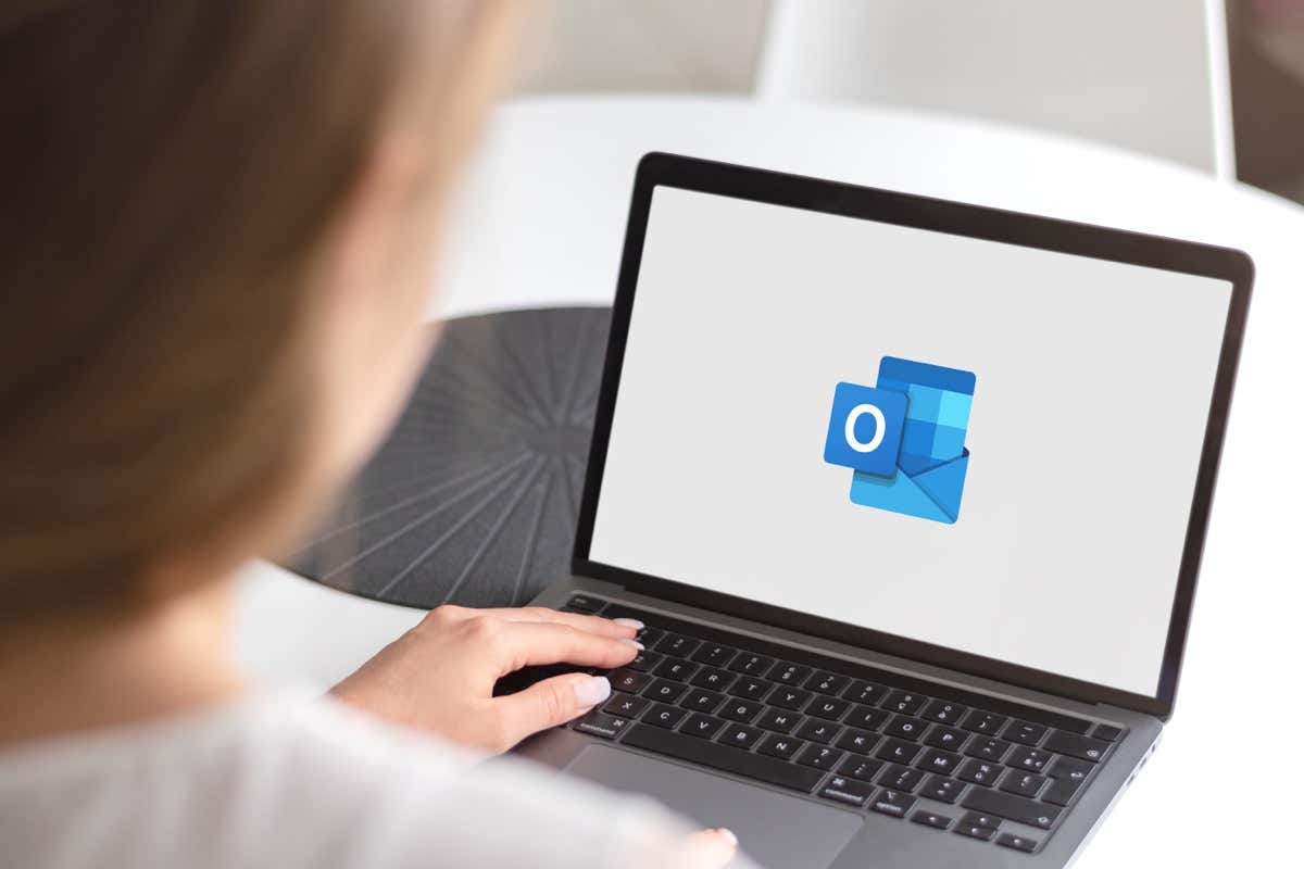 A laptop displays the Microsoft Office logo, showcasing its software; it sits on a surface against a blurred, light-blue background