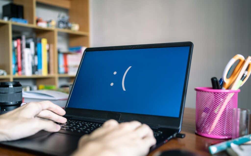 A Windows laptop on a table displaying the Blue Screen of Death.