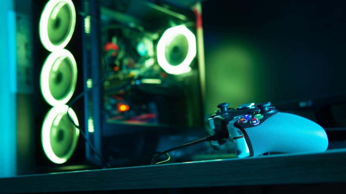 A computer tower, illuminated with green lighting, sits on a dark surface