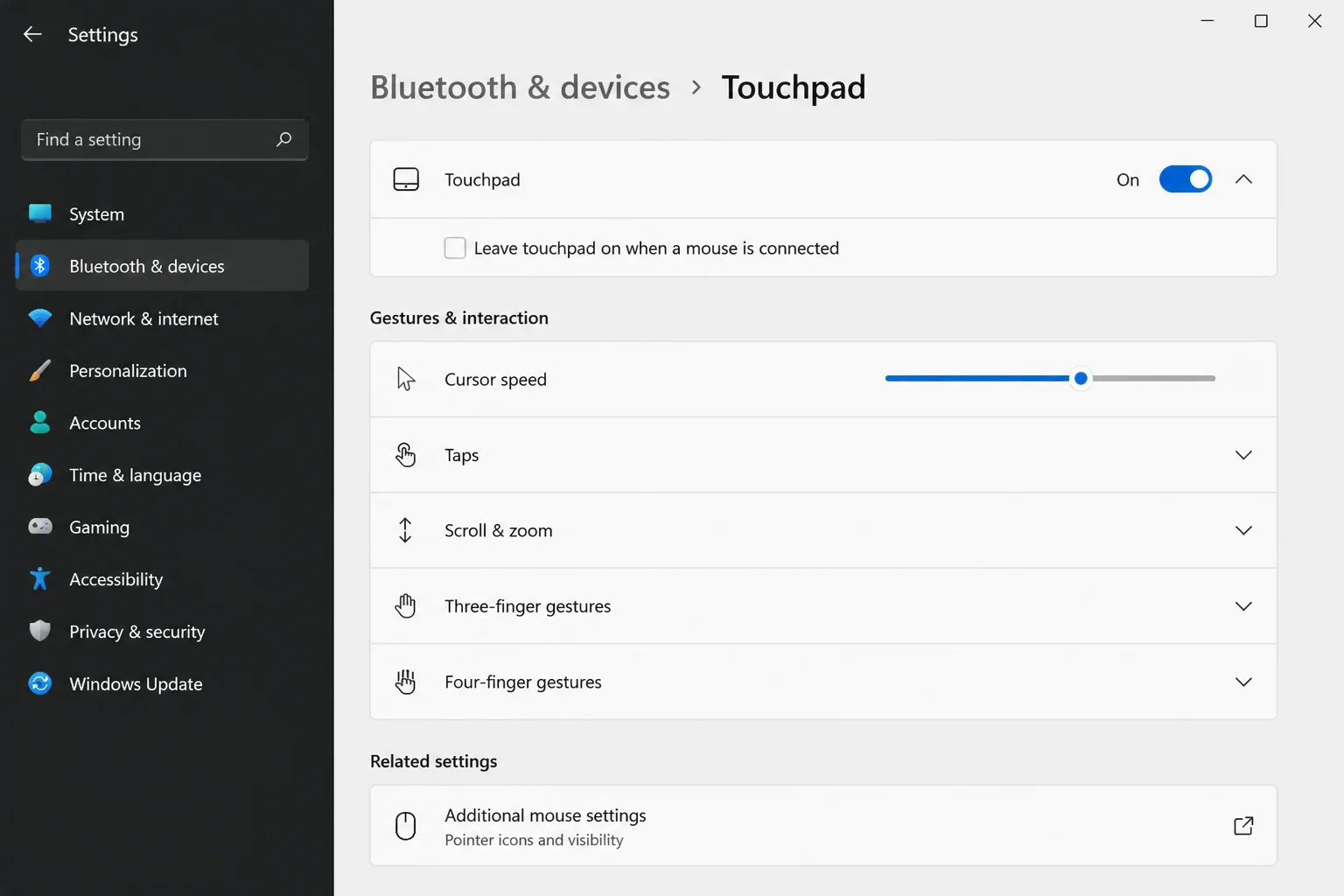 Windows 11 Settings > Bluetooth & devices > Touchpad page showing the main Touchpad on/off toggle switched On and the 'Leave touchpad on when a mouse is connected' checkbox