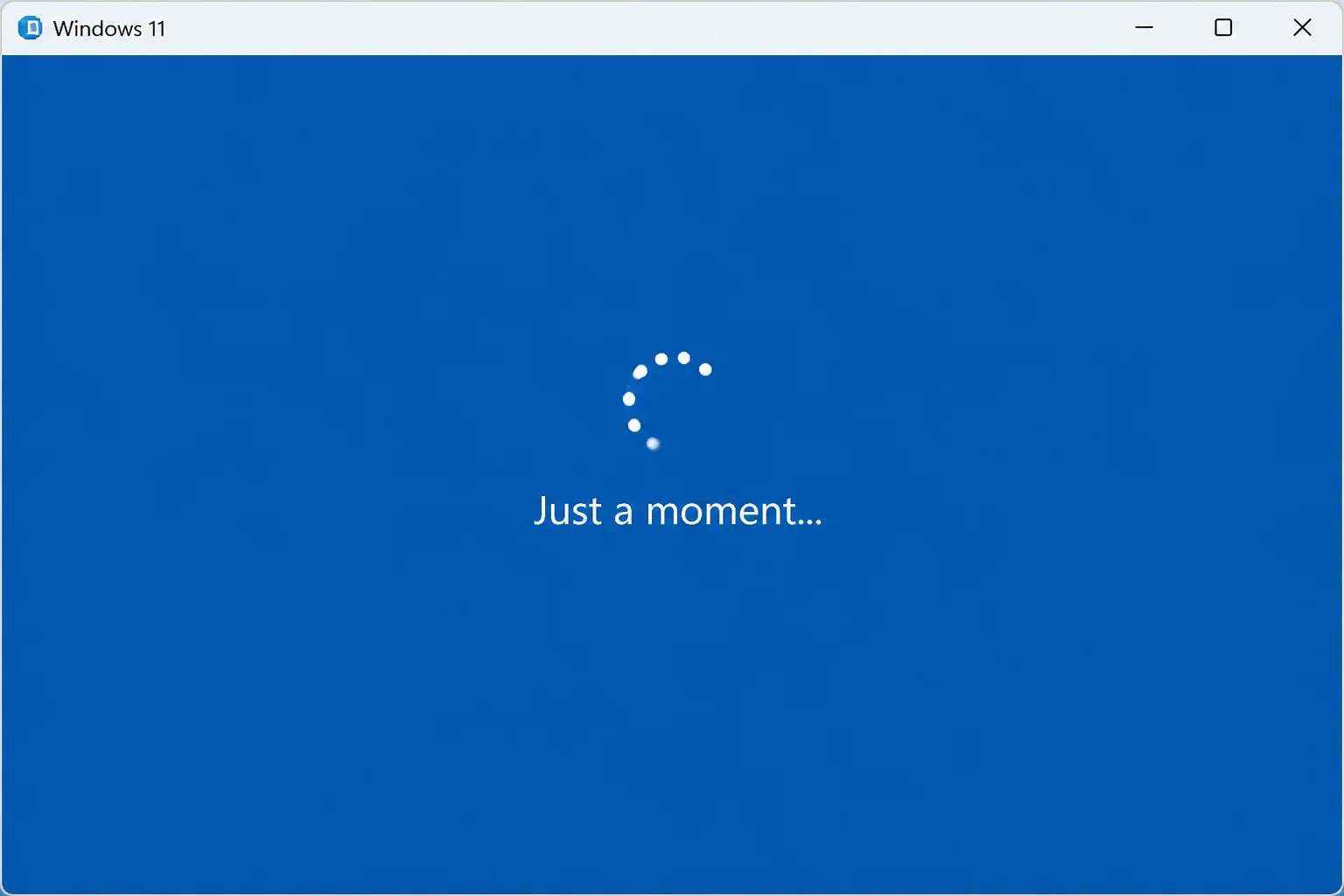 Windows 11 OOBE "Just a moment" screen with spinning dots and no progress bar or other interactive elements visible