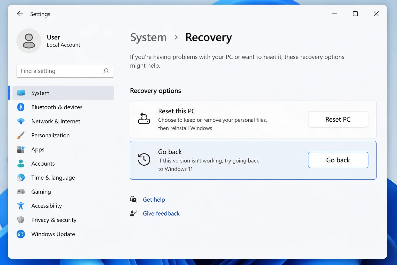 Windows 11 Settings > System > Recovery showing the "Go back" option under Recovery options
